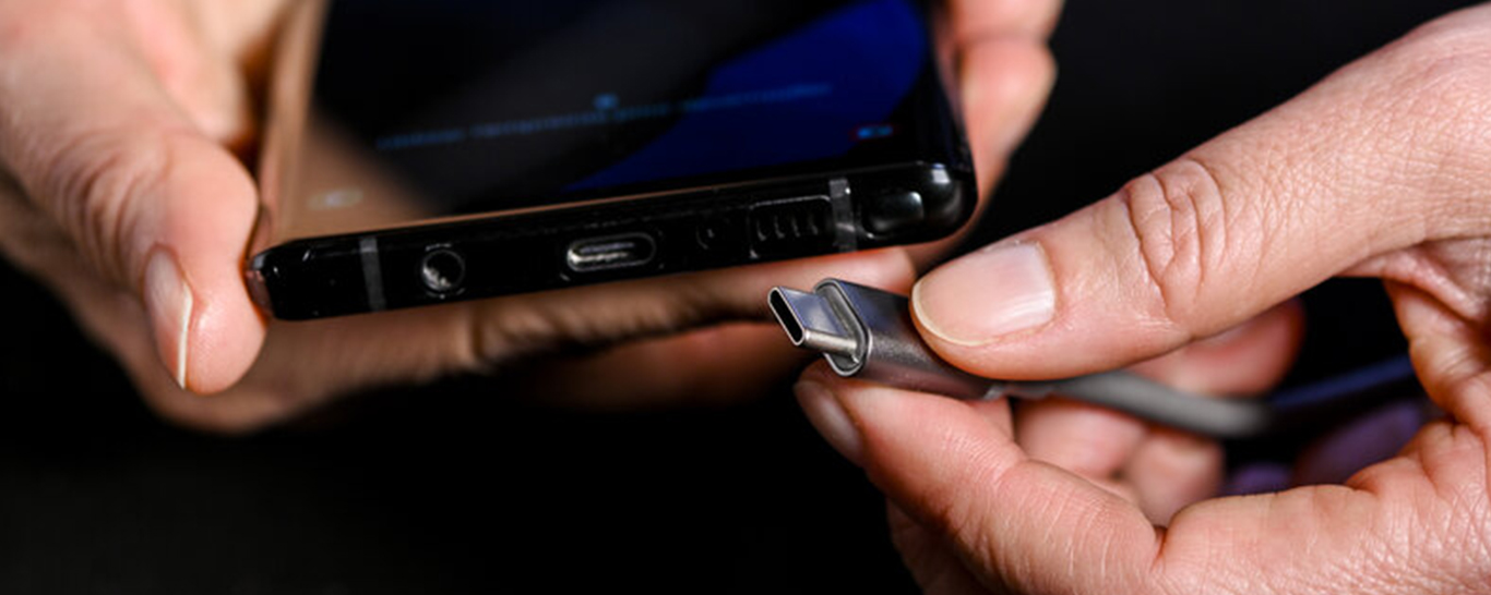 des mains tiennent un chargeur USB-C